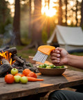 Orange vegetable crinkle-wavy chopper cutter with stainless steel blades, held outdoors near a campfire.