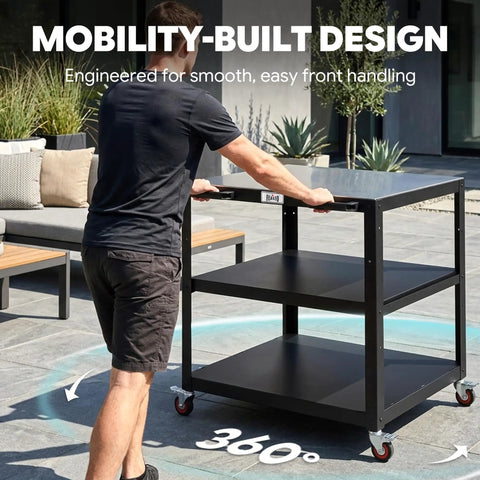 Person maneuvering Heavy Duty Outdoor Pizza Oven Table 36 By 24 Inches With Locking Wheels 304 Stainless Steel Worktop Built Tough Three Shelf Prep Unit For Deck Patio BBQ And Parties on patio.
