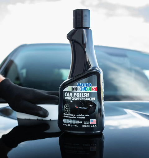 Black Car Polish 16 Oz For Deep Gloss And Scratch Repair on a car hood with a hand applying the polish, erases swirl marks and scuffs.