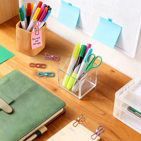 Slick 10 Pack Colorful Metal Chip Bag Clips With Rubber Finger Guards And Heavy Spring Steel Design on a desk with stationery.