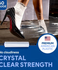 Person's leg in black shoe stretching clear 15 Inch Stretch Film Wrap Pack of 12 With Extended Tension Handles 1200 Feet for packing
