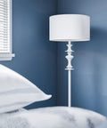 Claiborne Floor Lamp with Gloss White Finish in bedroom corner, showcasing 60-inch tall Nordic-inspired design, blue wall contrast.