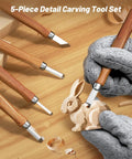 All-In-One Wood Carving Kit For Beginners with 5 detail knives carving a wooden rabbit, shown with gloves and wood shavings.