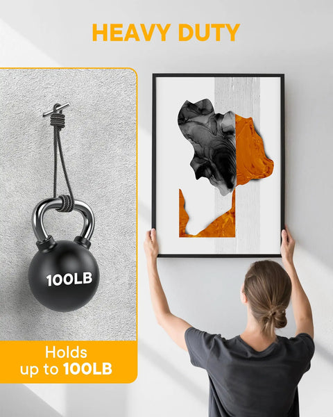 Woman hanging artwork using 40 Pack Picture Hangers Super Hooks For Drywall No Tools Needed Holds Up To 100 Lbs Silver Finish Heavy Duty Design.