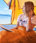 Person sitting in a tent with Warm Weather Sleeping Bag For Outdoors Portable Waterproof And Lightweight With Compression Sack