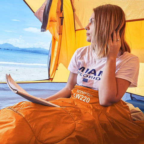 Person sitting in a tent with Warm Weather Sleeping Bag For Outdoors Portable Waterproof And Lightweight With Compression Sack