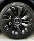 Snag These Fresh Multi Spoke Wheel Covers For Tesla Model Y 19 Inch Hubcaps 2020 To 2024 Four Piece Set viewed on a matte black wheel.