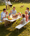 Family enjoying a meal outdoors on a White Folding Picnic Table Set With 2 Benches, 6 Feet Portable Outdoor Indoor Table And Chair Set.
