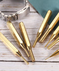 Brass Pro Grade Punch Set Eight Pieces with various sizes on wooden table for watch repair jewelry and craft projects.