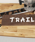 Heavy Duty Complete Sign Router Template Set For Custom Letters And Numbers In 1.5 Inch And 2.5 Inch Sizes With Full Alphabet And Characters Super Duper Easy Alignment For Your Weekend Shop Projects And Killer Diy Creations Right Now, showing the word TRAIL on wood.