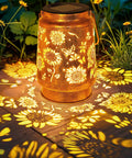 Solar Lanterns Outdoor Hanging Lights Waterproof For Yard Patio Porch Garden LED Decoration With Shepherd Hook Sunflower Pattern Cozy Warm Glow For Nighttime Ambiance Perfect Gift For Women Mom Grandma, casting floral shadows on ground.