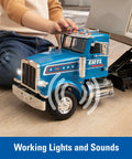 Child playing with Blue Peterbilt 1/16 Scale Dump Truck Toy With Working Dump Bed, showcasing realistic lights and sounds.