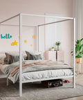 Full Size Canopy Bed Frame with Heavy Duty Metal Slats in White Four-Poster Style, styled in a cozy bedroom.
