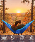 Couple relaxing in blue Ultra Lightweight Parachute Nylon Hammock With Tree Straps For Camping Backpacking Hiking Or Beach Adventures
