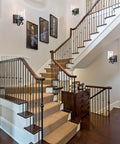 Winsmart Black Wall Sconces Set of Two Hard Wired, mounted on staircase wall, illuminating clear glass shade for ambiance.