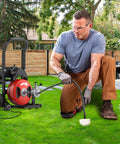 Powerhouse Electric Drain Auger With Auto Feed Design Tough As Nails 75 Foot Steel Cable Sewer Snake in use outdoors.