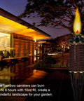 Outdoor bamboo torch lit at night next to modern house, showcasing Torch Replacement Canisters For Bamboo Lanterns, Refillable Outdoor Torches, Yard Patio Deck Garden Party Decor, 16oz 6 Pack, Easy Swap For Cozy Outdoor Vibes And Nighttime Ambience
