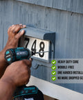 Person using a drill with Top Shelf Exterior Wood Screws Assortment Kit With One Hundred Eight Badass Carbon Steel Fasteners In Six Pro Sizes With Corrosion Resistant Grey Coating Plus Two Tough Hex Bits Stashed In A Sweet Plastic Organizer Box For Your Next Backyard Project to install house numbers.