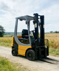 Heavy Duty Electric Forklift Truck Featuring Punchy Motors And Rock Solid Tires streamlined for outdoor maneuvering on dirt path.