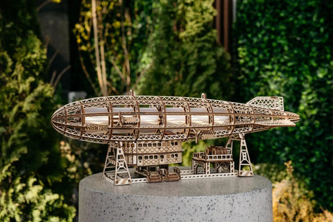 Luminous Zeppelin LED 3D Wooden Puzzle Kit For Adults displayed outdoors on a stand, showcasing vintage airship design.
