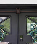 Heavy Duty Adjustable Front Door Garland Hanger With Padded Ends Providing Rock Solid Grip On Jambs From 51 To 81 Inches, holding festive wreaths.