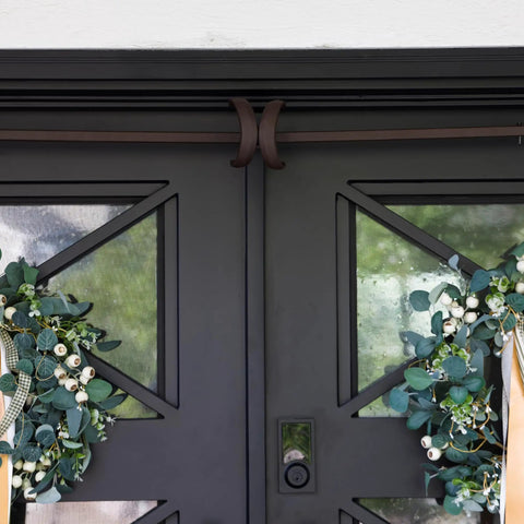 Heavy Duty Adjustable Front Door Garland Hanger With Padded Ends Providing Rock Solid Grip On Jambs From 51 To 81 Inches, holding festive wreaths.
