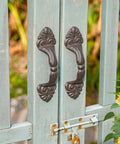 Vintage Cast Iron Door Handle Set 2 Pack Built Tough For Farmhouse Style Cabinet Pulls And Sliding Doors Fence Gates Cupboards Durable Antique Brown Finish attached to a blue gate with sunflower accents
