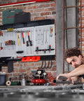Pegboard Wall Organizer Kit 48x36 Inch Heavy Duty Metal Pegboard With Toolboard And 105-Piece Hook Set, Overhead Shelf And Utility Hooks For Garage, Workshop, Basement All In One Storage System installed on a brick wall with tools organized.