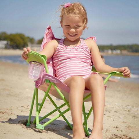 Child seated on Kid Sized Butterfly Back Folding Chair With Built In Cup Holder In Armrest, enjoying a sunny beach day.