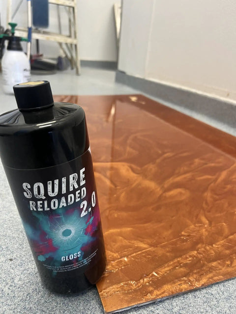 Squire Two Zero Reloaded Pro Grade Sealer For Concrete Epoxy Natural Stone Vct Lvt Lvp Tile And Grout Substrates With Gloss Finish One Quart Coverage Up To 250 Sqft with glossy copper surface in background.