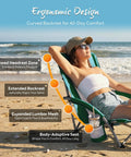 Person relaxing on a Low Profile Folding Beach Chair With Cup Holders And Carry Bag, showcasing ergonomic design on the beach.