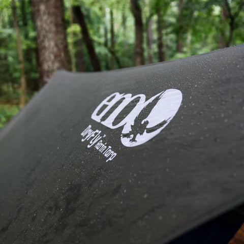 Logo on DryFly Rain Tarp Ultralight Hammock Shelter, water shedding polyurethane treated ripstop nylon in forest setting