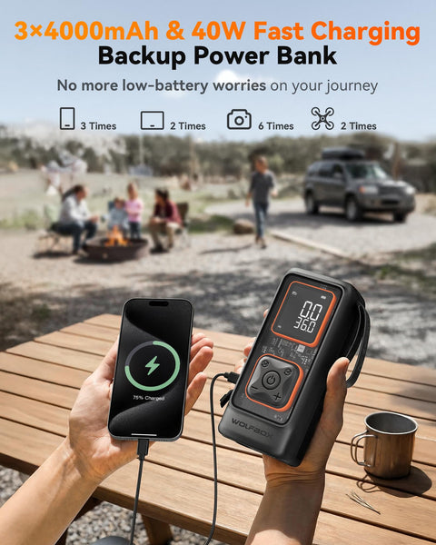 Hand holding a power bank charging a smartphone outdoors with a digital display showing battery level, people and a car in the background.