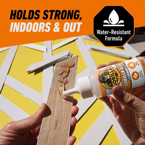 Gorilla Clear Glue 3.75 oz bottle applying clear glue to wood plank (close-up)