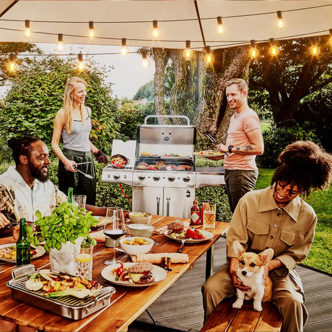 Outdoor String Lights 150 Ft With 75 Shatterproof G40 LED Bulbs 3 Spare Dimmable Warm White 2700K Waterproof Patio Cafe Backyard Market Lighting For Outdoor Parties Expandable Up To Six Strands illuminating a backyard dinner scene with people around a table and a grill.