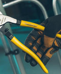 Tough Nine Inch Cable Cutter With Comfort Dipped Grips And Solid Forged Steel Arms held in gloved hand for electrical wire snipping.