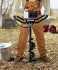Person using Gas Powered Post Hole Digger With 43cc Engine And 8 Inch Auger Bit, 30 Inch Alloy Shaft in a garden