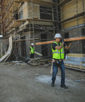 Mens High-Vis Mesh Vest With Zip-Front And Neon Lime Shade To Stay Fresh While Working Hard worn by a worker carrying lumber on a construction site.