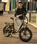 Person standing with e-bike on boardwalk, showcasing Heavy Duty 20x4 Fat Tire Inner Tubes For E Bikes And Mountain Bikes With Schrader Valve Fits 20x3.5 To 4.0 Inch Wheels Extra Thick Durable Tubes Built For Fat Tire Rides 2 Pack.