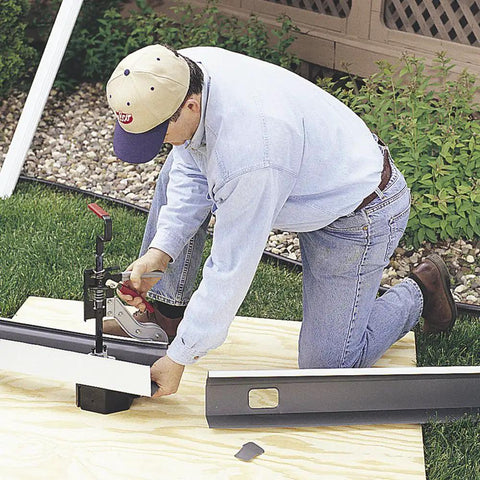 Person using Ratcheting Gutter Outlet Punch Tool Frame For Quick Holes In Aluminum Gutters With Angled Punch Blade And Ample Throat Clearance Bench Mount Ready Delivers Precise.032-Inch Fastener Holes And Smooth Cutting Action outdoors