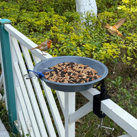 No Bull Fully Adjustable Deck Mounted Birdbath With Secure Grip Rail Clamps, gray bowl on railing with birds and seeds.