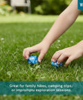 Hands holding Oversized 8-Sided Wooden Dice Set For Outdoor Adventures With Directional And Number Dice on grass.