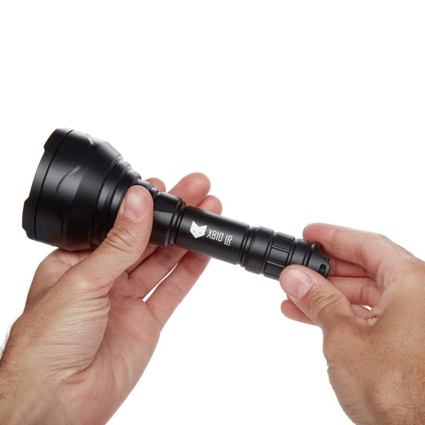 Hands holding XB10 Infrared Torch For Night Vision Gear 5W IR Illuminator 940nm With 67mm Aspherical Lens showing its compact size.