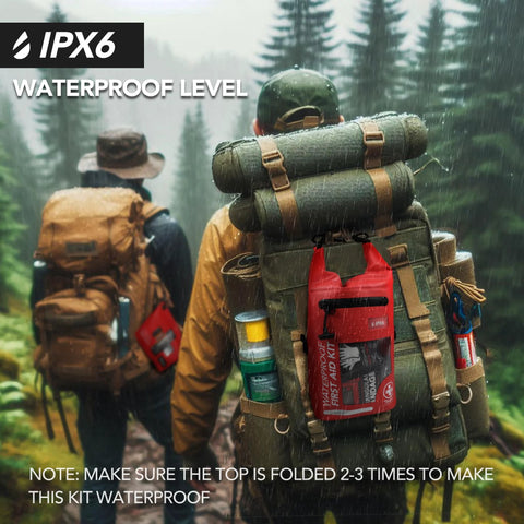 Red waterproof first aid kit attached to a green hiking backpack in rainy forest.