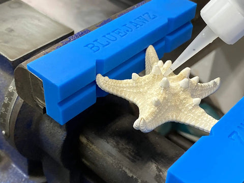 Heavy Duty Heat Resistant Magnetic Soft Jaws For Bench Vise Drill Press Clamps fitted on a workbench, securing a starfish.
