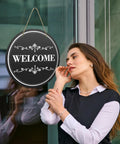 Woman beside door with Six Round Sublimation Door Hanger Blanks For DIY Wall Decor, 10 By 10 Inch MDF Wood Circles with rope.