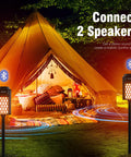 2-Pack Outdoor Torch Atmosphere Bluetooth Speakers, 10W Portable IP65 Waterproof LED Flame Lights in front of a lit tent
