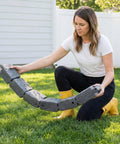 Woman holding Faux Stone Landscape Edging Kit 15.5 Ft No Dig Border For Lawn And Garden Beds with Realistic Texture 4 Pack of Sections.