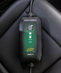 Dead Simple 16 Amp Level One Portable Ev Charger on a car seat with a digital display showing charge levels.