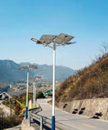 Heavy Duty Solar Security Lights Bringing Knockout Visibility With Smart Motion Sensor LED Flood Lighting And No Sweat Installation For Fences And Porches line the road in a mountainous area.